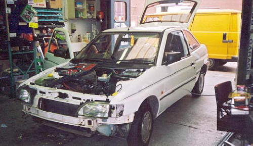 Various stages of construction of three identical Ford Escort Cosworth rally 